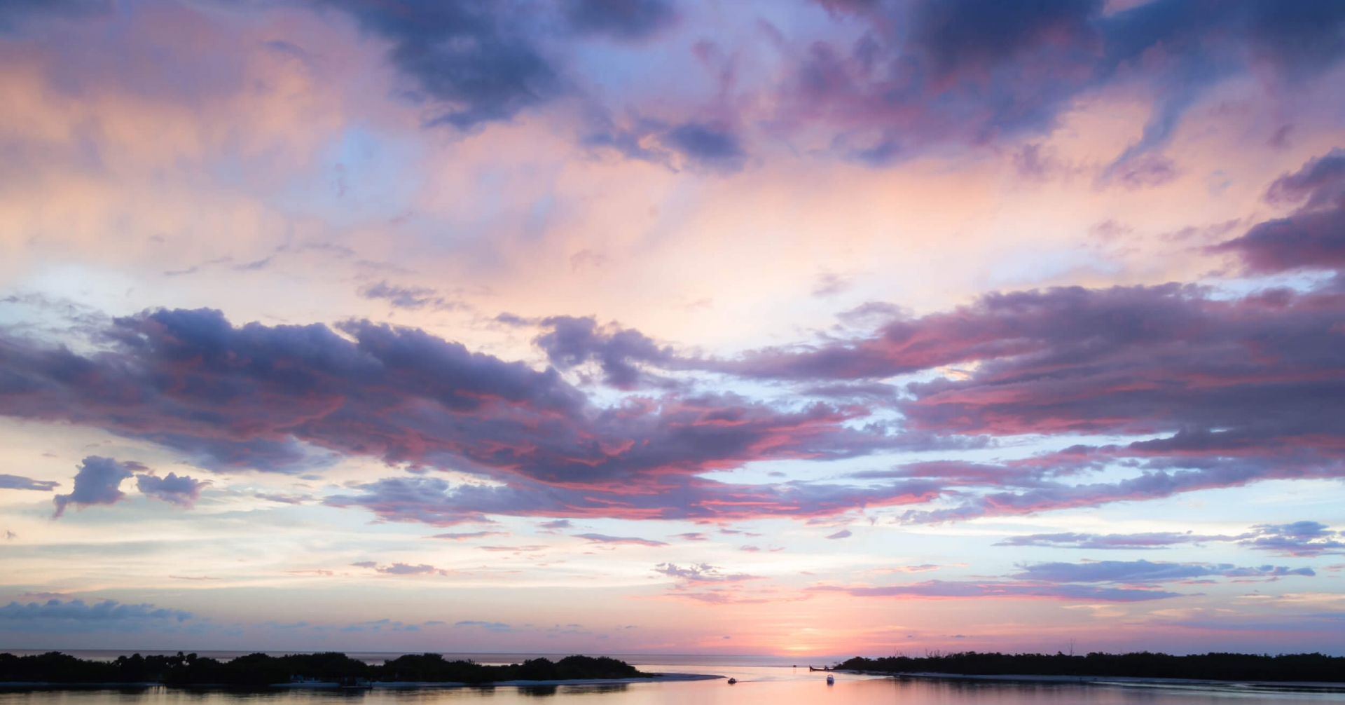 A body of water with a sunset in the background