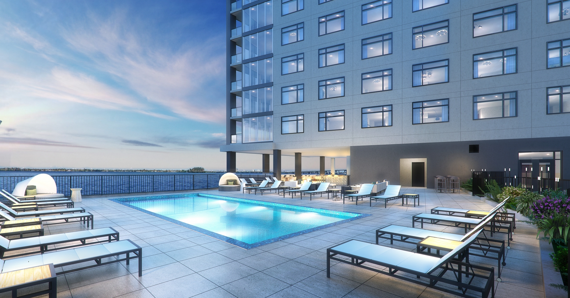 A pool and lounge chairs on a rooftop of a building