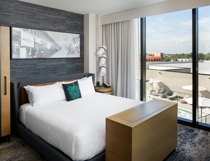 A bed with a wood table and a window