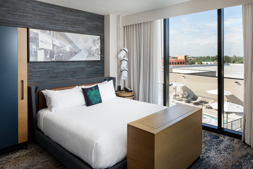 A bed with a wood table and a window