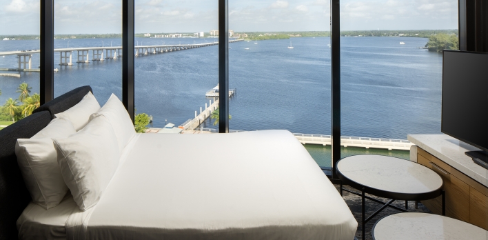 A room with a view of the water and a bridge