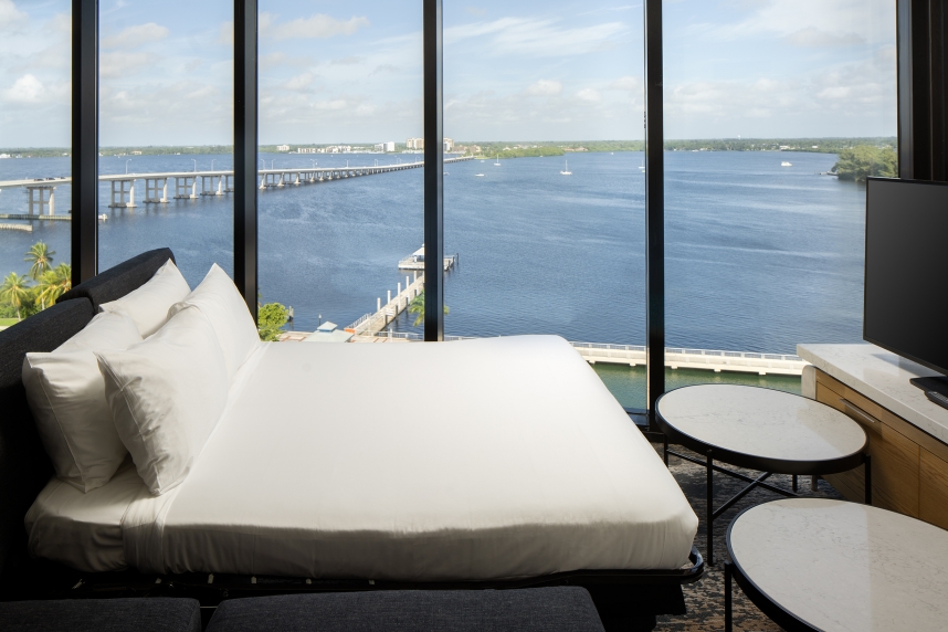 A room with a view of the water and a bridge