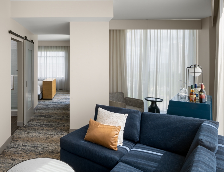A living room with a blue couch and a blue chair