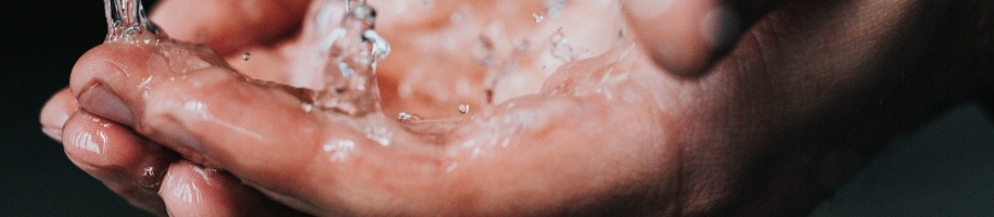 Person holding hand under tap, washing hands