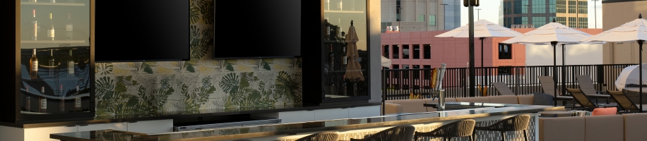 An outdoor bar with chairs and a tv on the wall