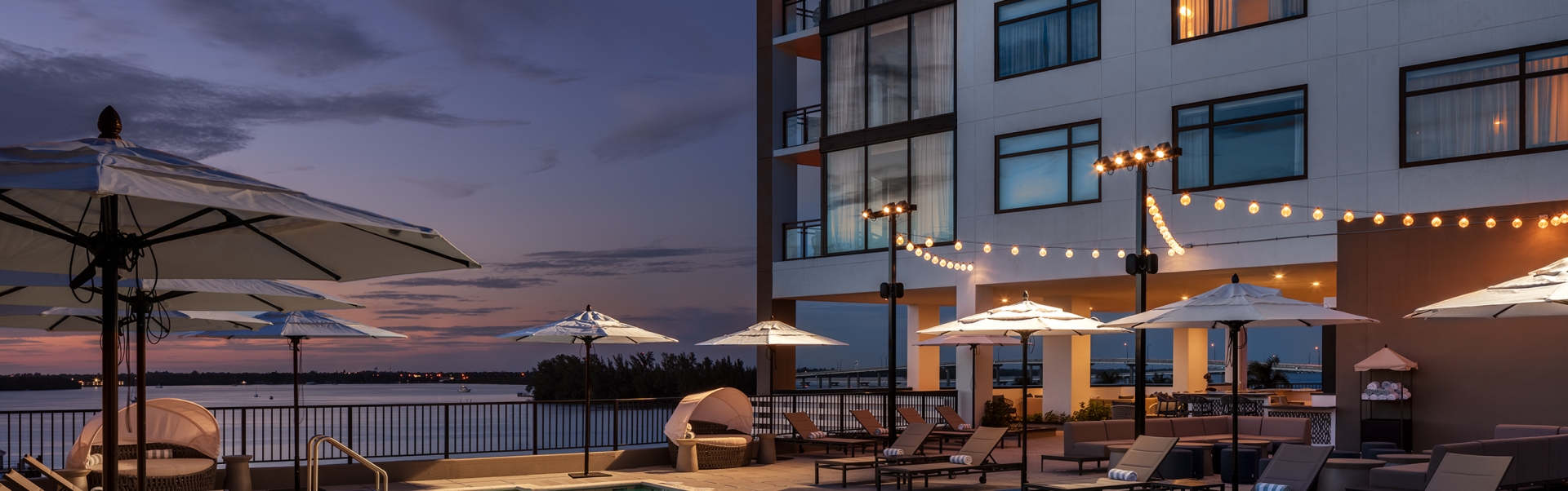 A pool with chairs and umbrellas next to a building