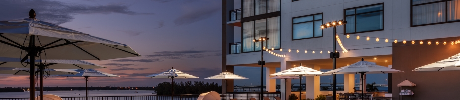 A pool with chairs and umbrellas next to a building